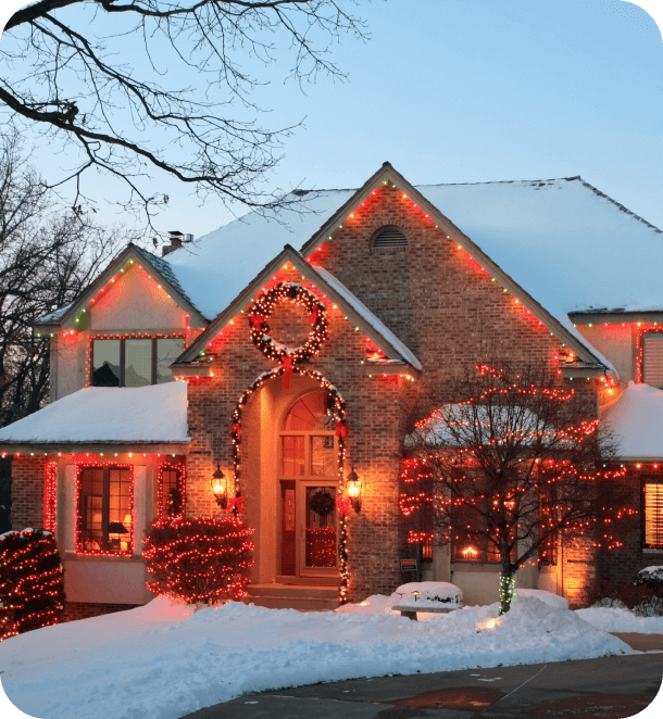 Holiday lights installation on peaks, arches, bushes and trees in front of house