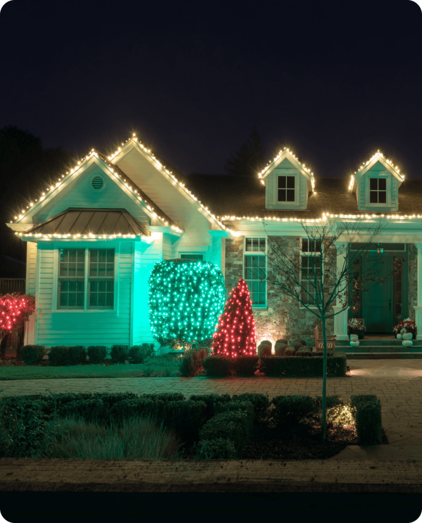 Large ranch house with christmas light installation on peaks and bushes